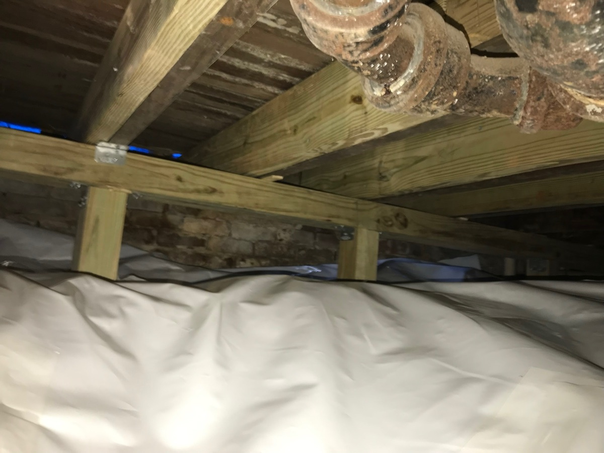 Reinforced floor joists with new structural support after foundation repair