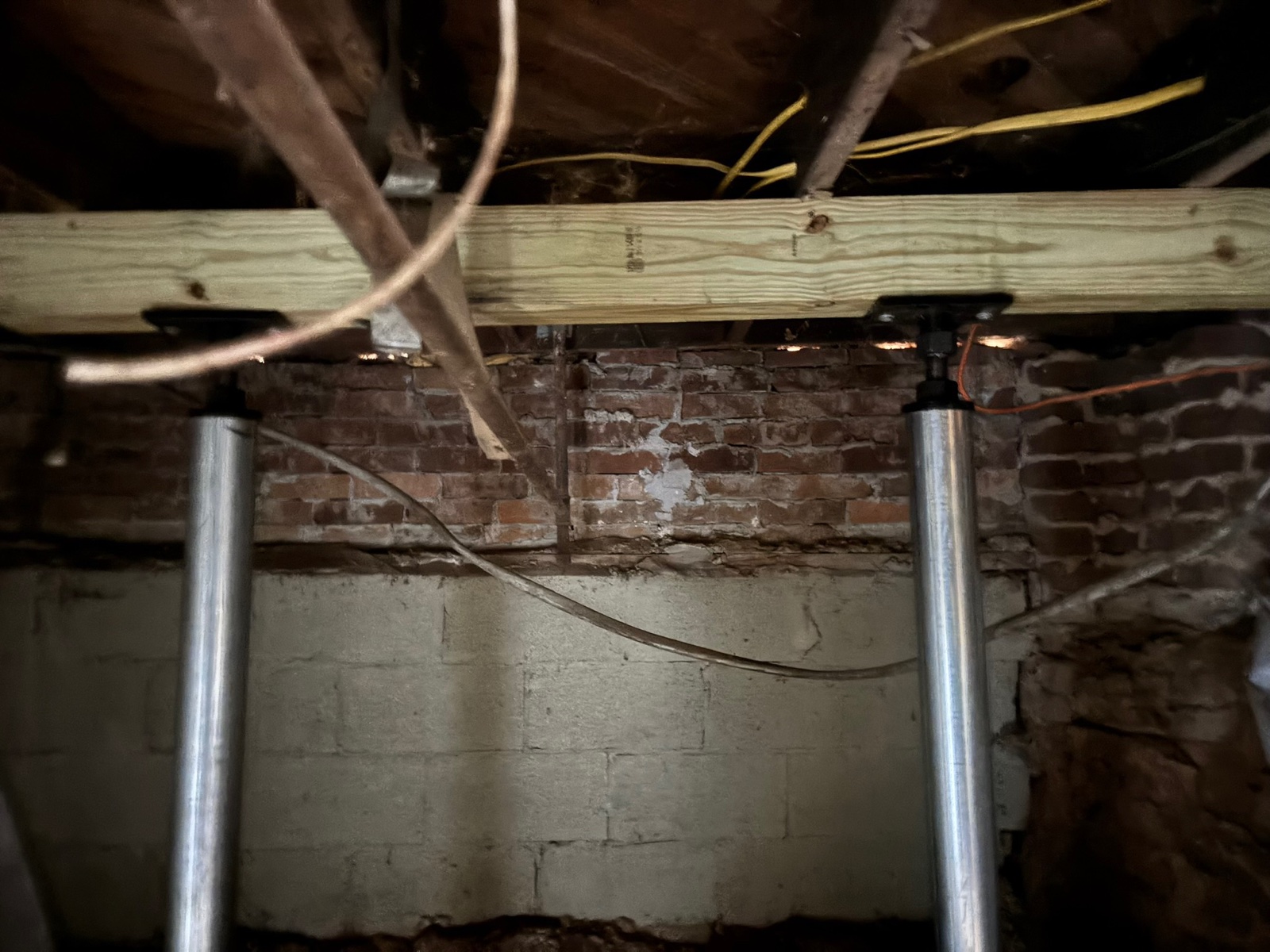 Row of installed steel SmartJack stabilization columns under a Metro Atlanta home — Crawl Daddy foundation repair